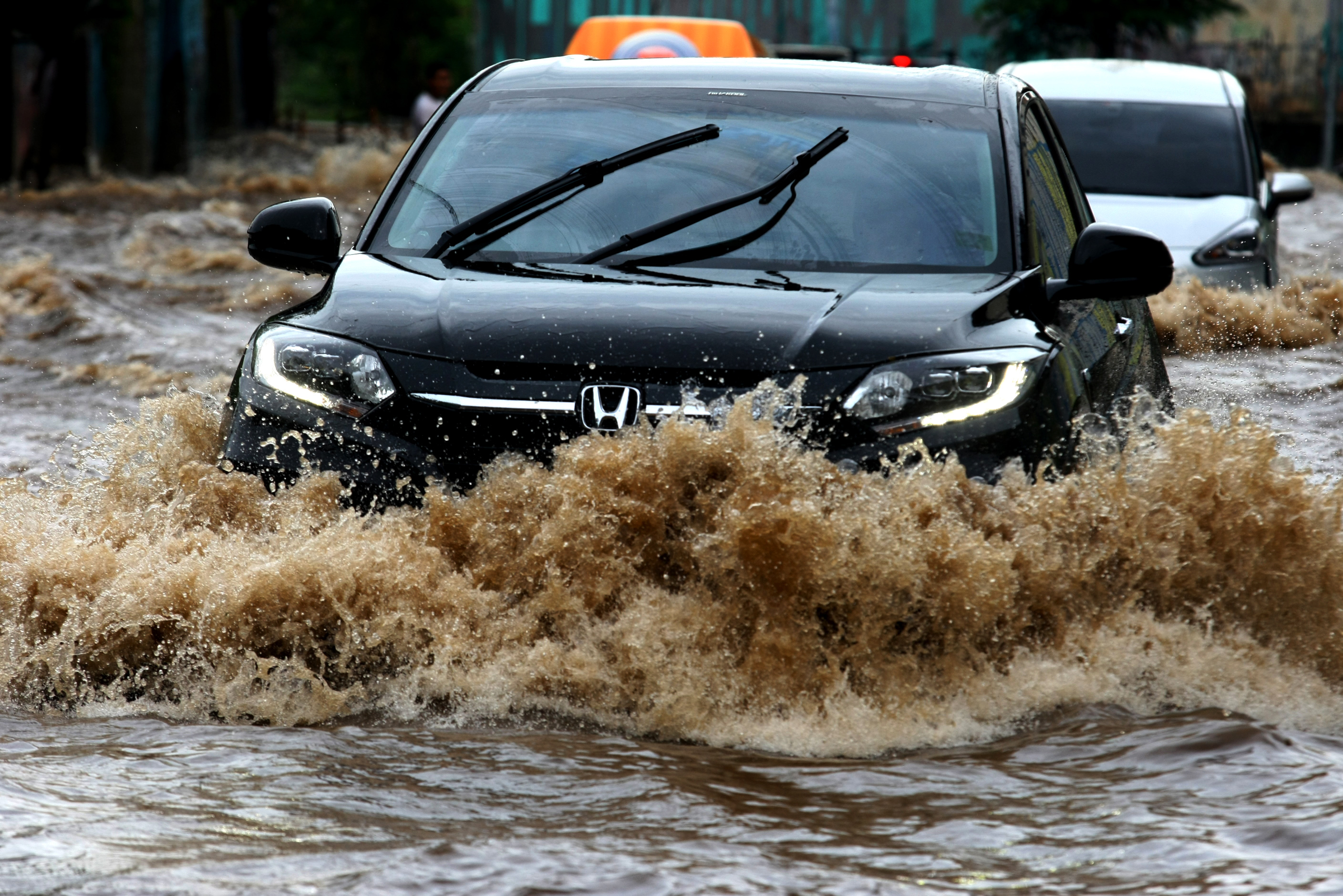 Tips, Pengendara mobil menerobos banjir di kawasan Tegalrotan, Tangerang Selatan, Banten, Selasa (21/2).: Banyak Jalanan Banjir? Baca Dulu Tips Aman Menerobos Banjir Berikut Ini